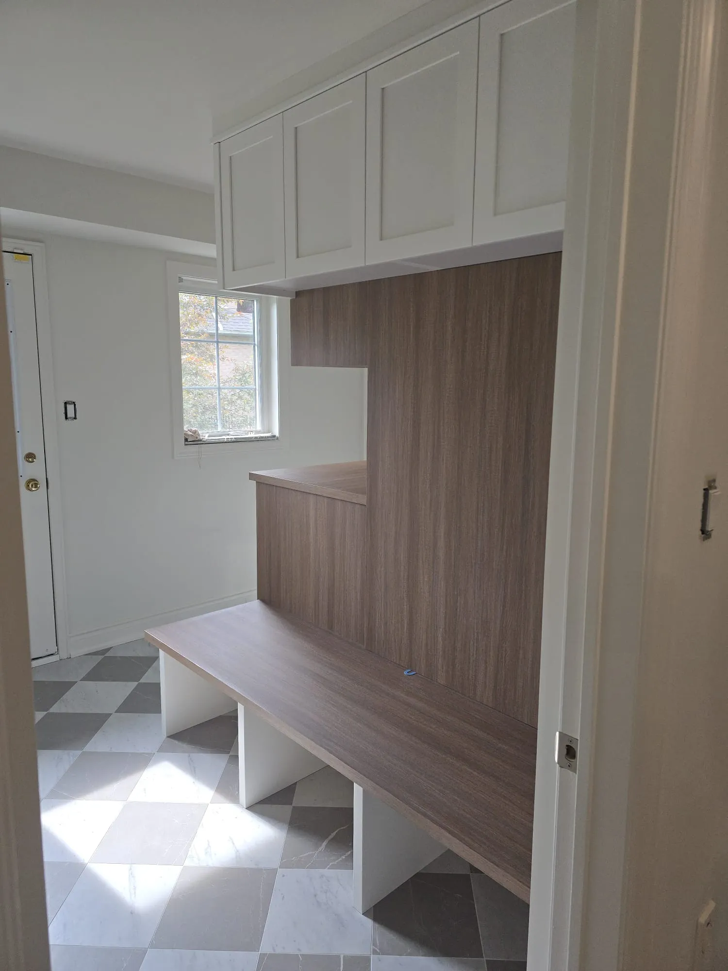 Custom wood mudroom bench and tall storage cabinet