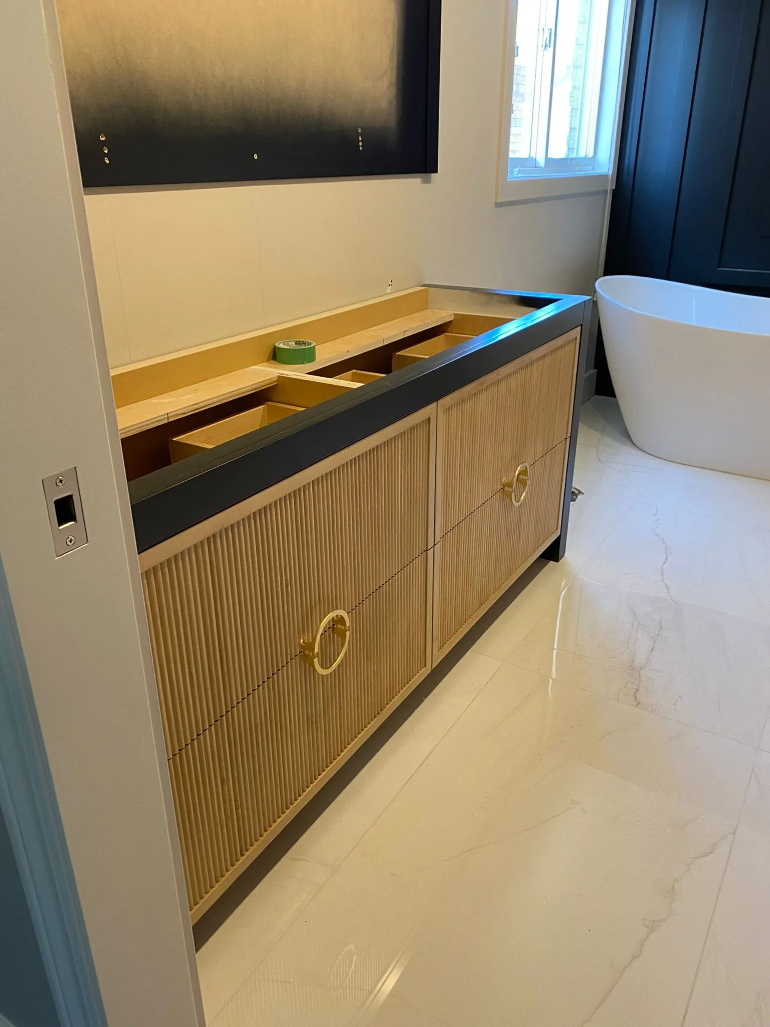 Floating wood bathroom vanity with fluted drawer fronts