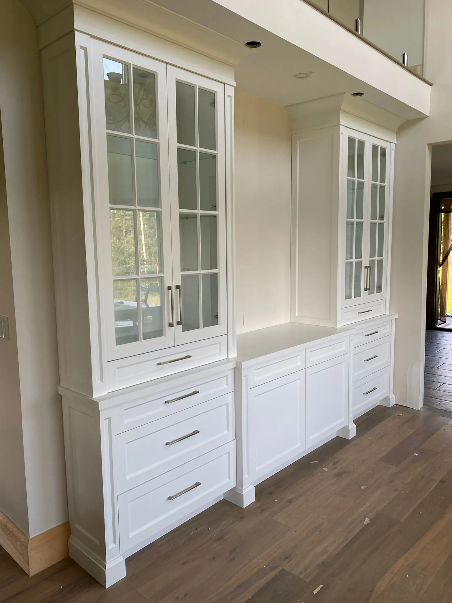 White glass-front built-in cabinets with drawers