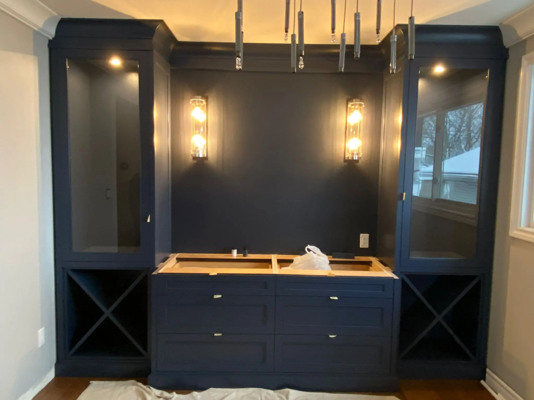 Navy blue bathroom vanity between matching open shelves