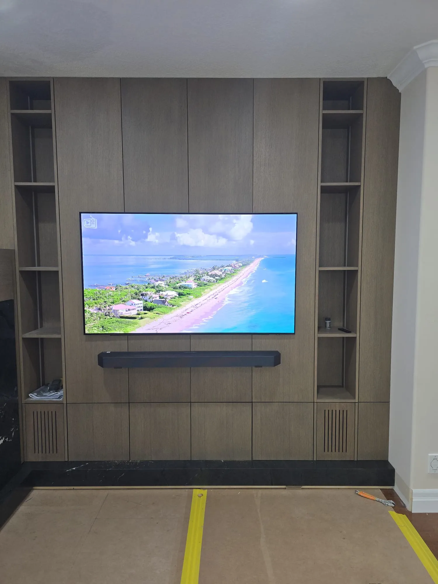 Wall-to-wall walnut media centre with open display shelves