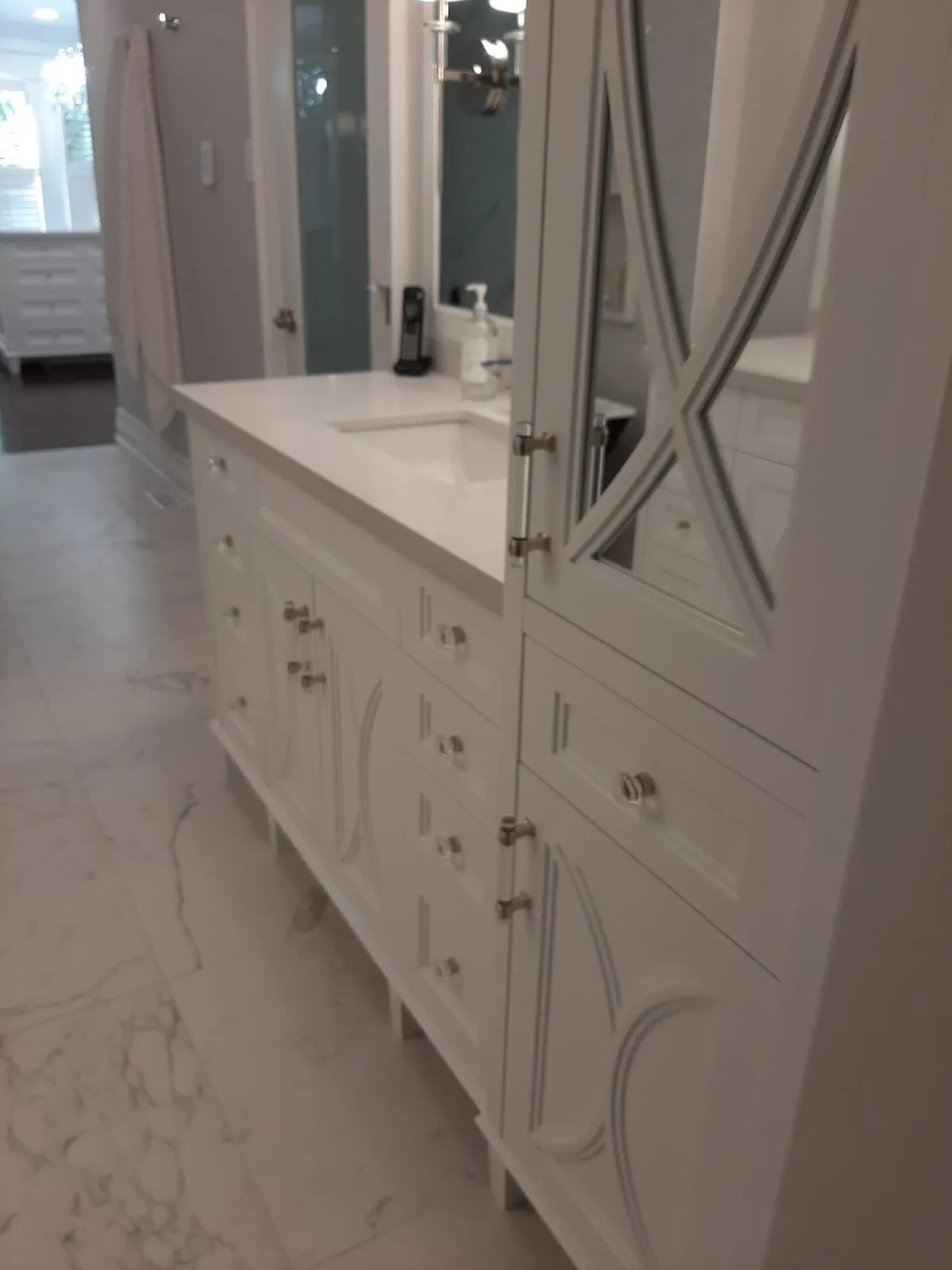 Long white bathroom vanity with tower cabinets and mirrored doors