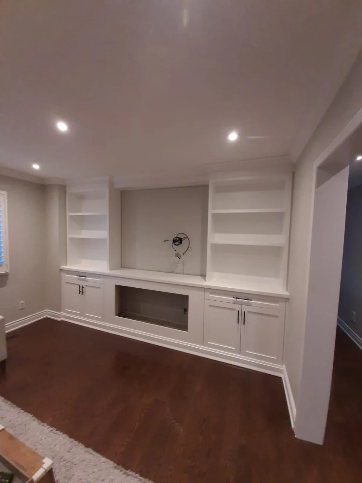 White living room built-in with shelves and a low media cabinet